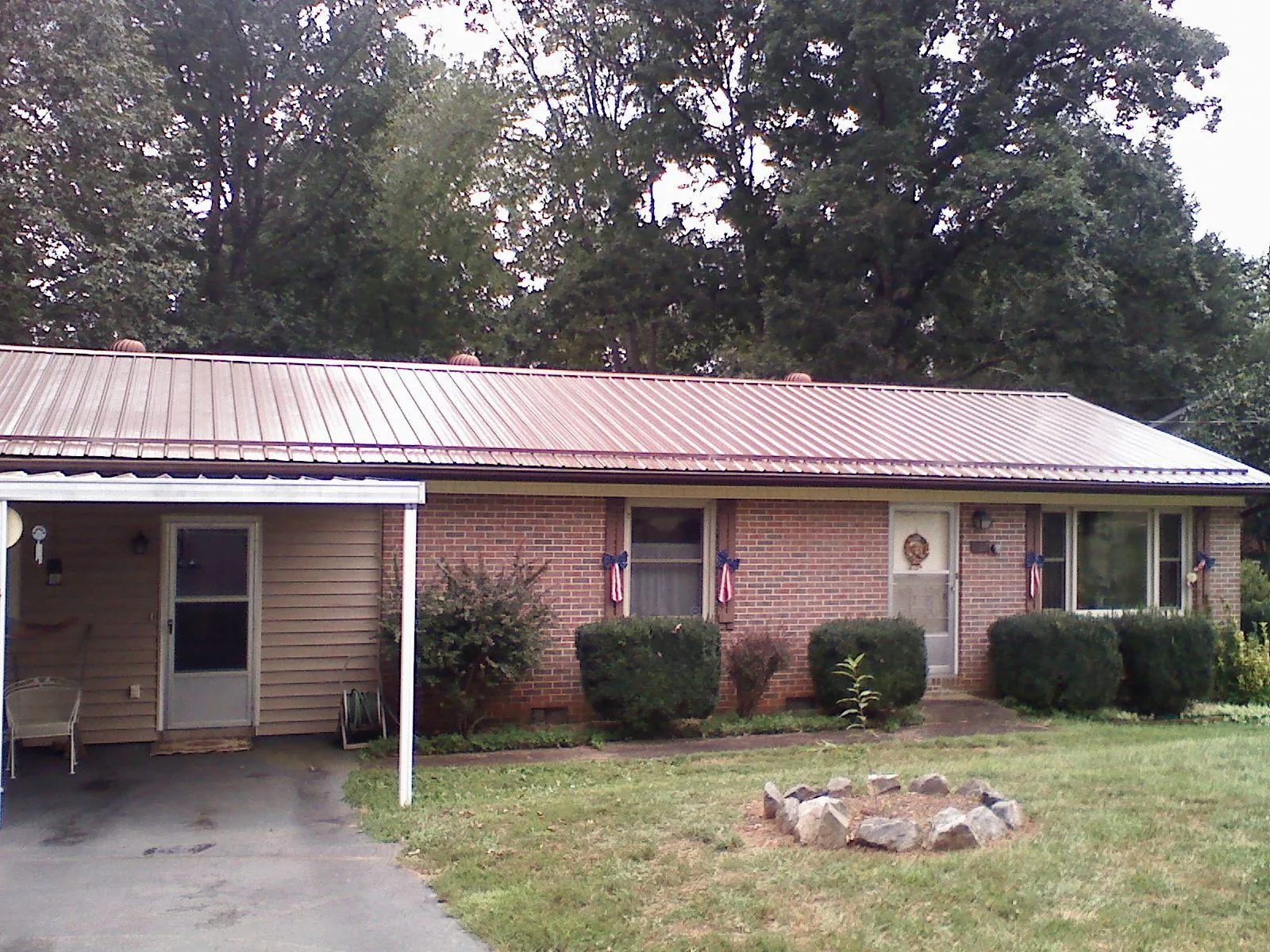 Bronze metal roof and carport on a brick ranch home — Roof Repair work by our crew in Bozeman